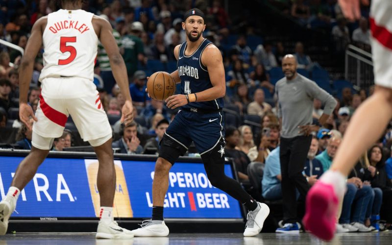 Mar 17, 2024; Orlando, Florida, USA; Orlando Magic guard Jalen Suggs (4) dribbles the ball against Toronto Raptors guard Immanuel Quickley (5) in the first quarter at KIA Center. Mandatory Credit: Jeremy Reper-USA TODAY Sports