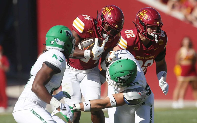 Iowa State Cyclones running back Abu Sama III (24) battles for a few yards as getting a tackle North Dakota Fighting Hawks defensive back Clayton Bishop (5) and linebacker Dylan Boecker (32) during the third quarter in the season opening game at Jack Trice Stadium on Aug. 31, 2024,  in Ames, Iowa